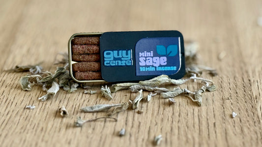 Mini sage incense packaging with incense sticks on a wooden surface